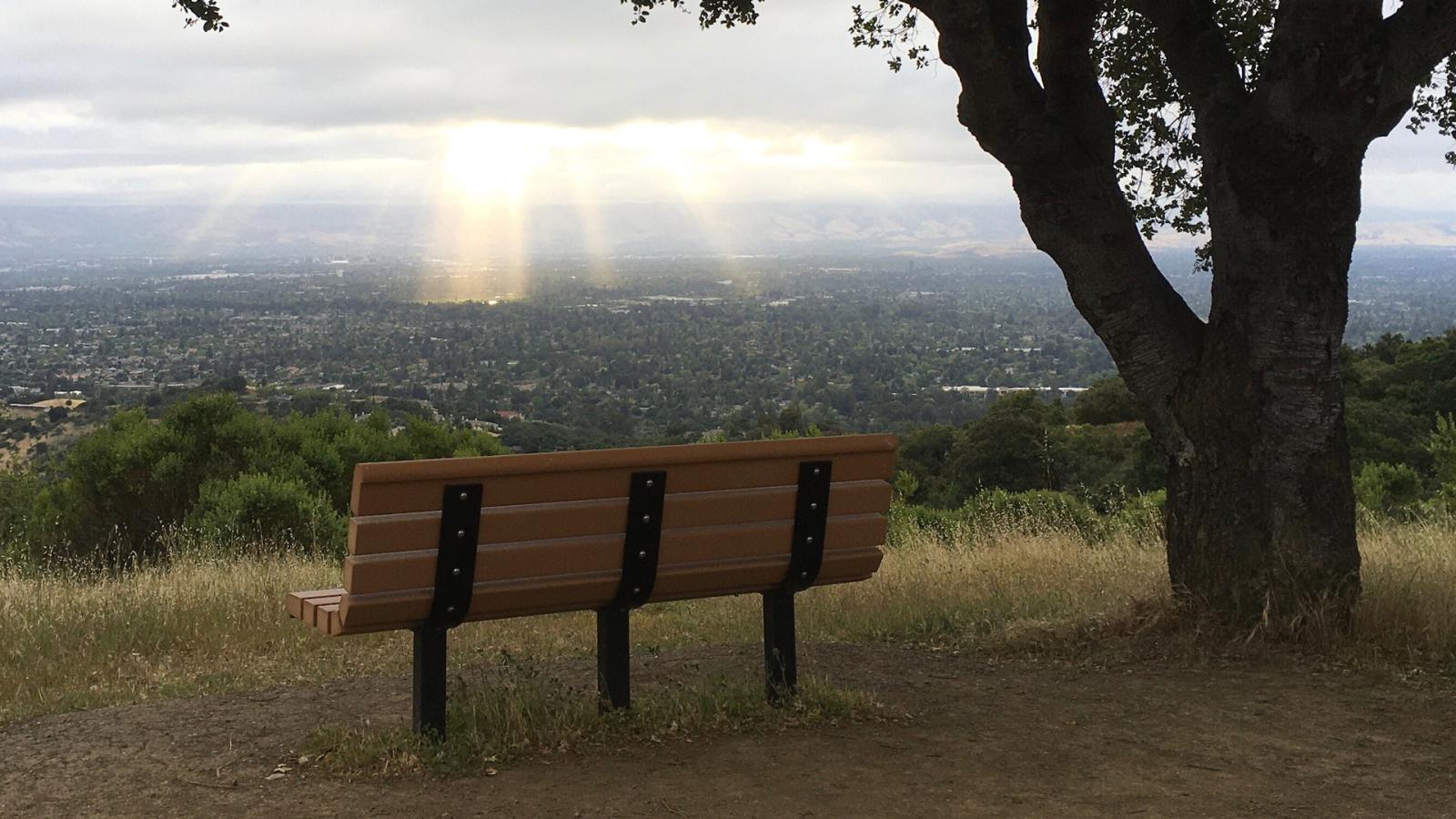 a bench on a hilltop overlooking the valley below